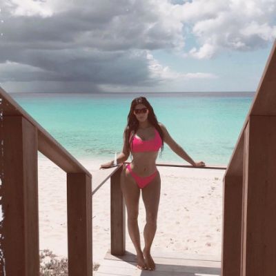 Kim Kardashian posa de biqu�ni neon em frente a paisagem paradis�aca